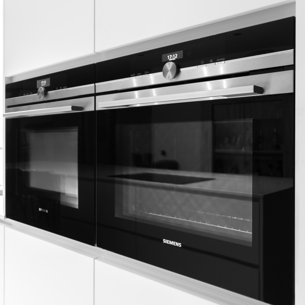 Strakke witte keuken met subtiele ingebouwde verlichting, ontworpen voor functionaliteit en een moderne esthetiek